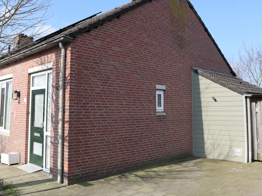 Gevel en omheining van woning gereinigd vóór de werkzaamheden